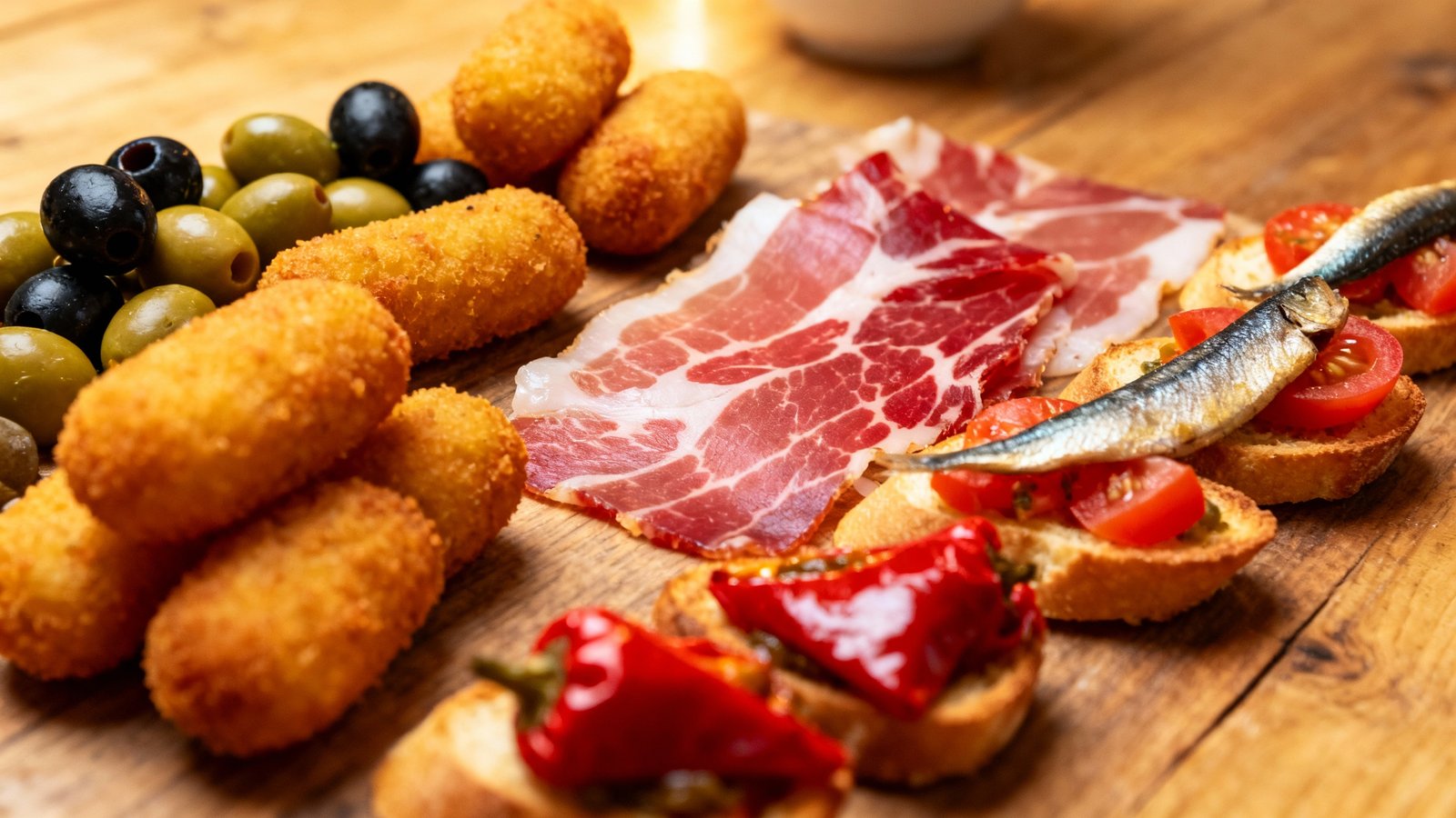 A delicious spread of colorful Spanish tapas and pintxos on a wooden table in a rustic Barcelona bar