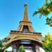 Eiffel Tower with lush trees and blue sky.