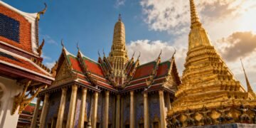 The Grand Palace shimmering in Bangkok’s daylight, ornate golden spires and vibrant rooflines, ultra-realistic, cinematic wide angle