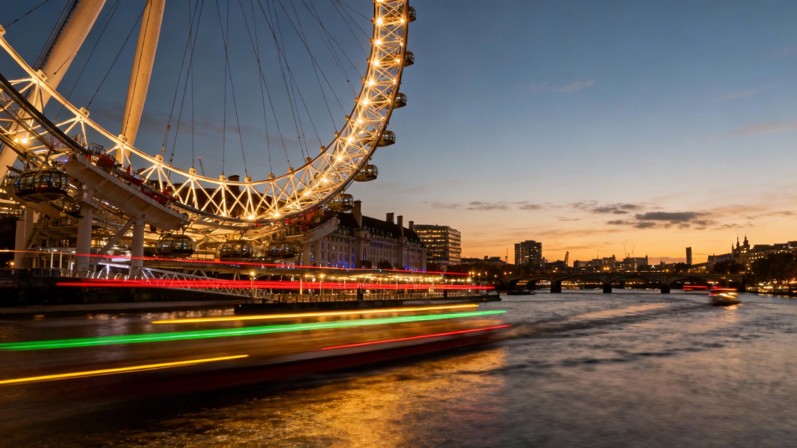 The London Eye illuminated at dusk, with colorful light trails from boats on the River Thames below